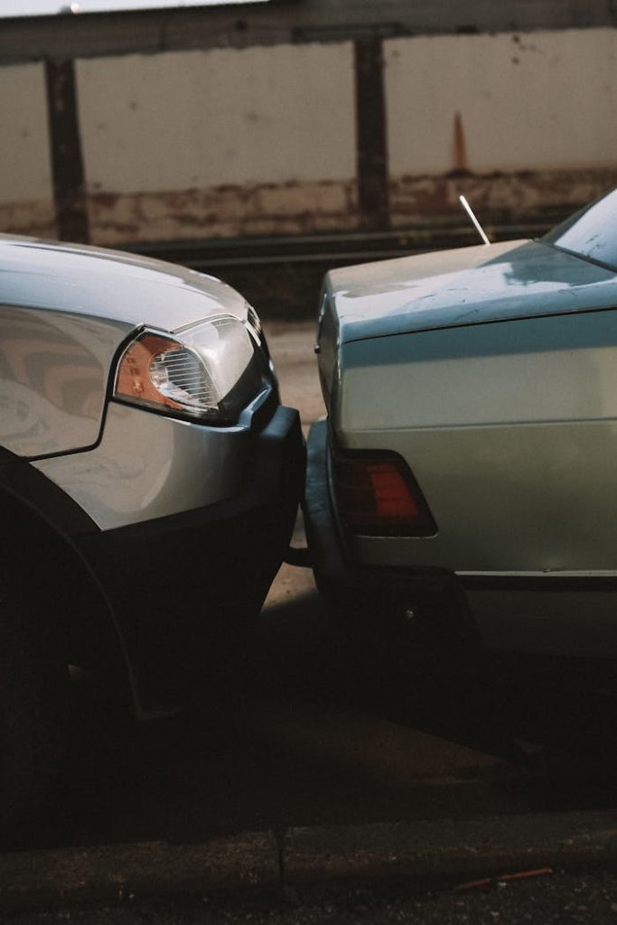 A close-up view showing the aftermath of a rear-end car collision in an outdoor setting.